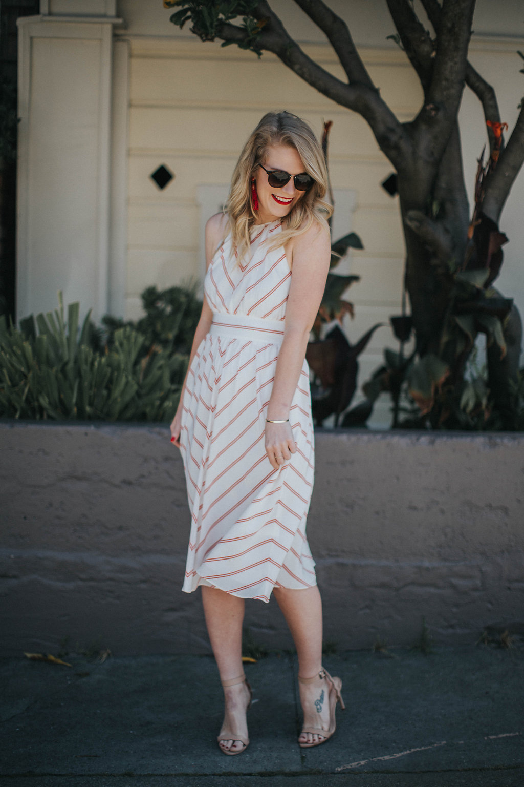 Cait Weingartner wears a swingy striped Club Monaco dress with Loeffler Randall heels and BaubleBar earrings.